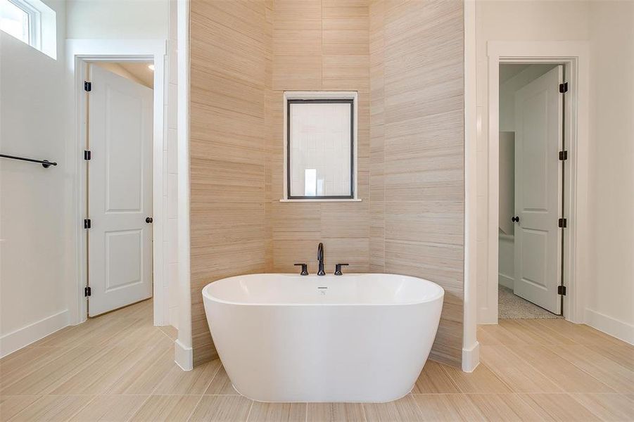 Bathroom featuring a tub, tile walls, and tile patterned floors