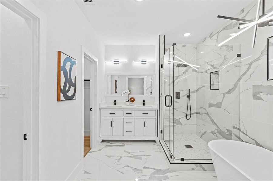 Bathroom featuring vanity and separate shower and tub