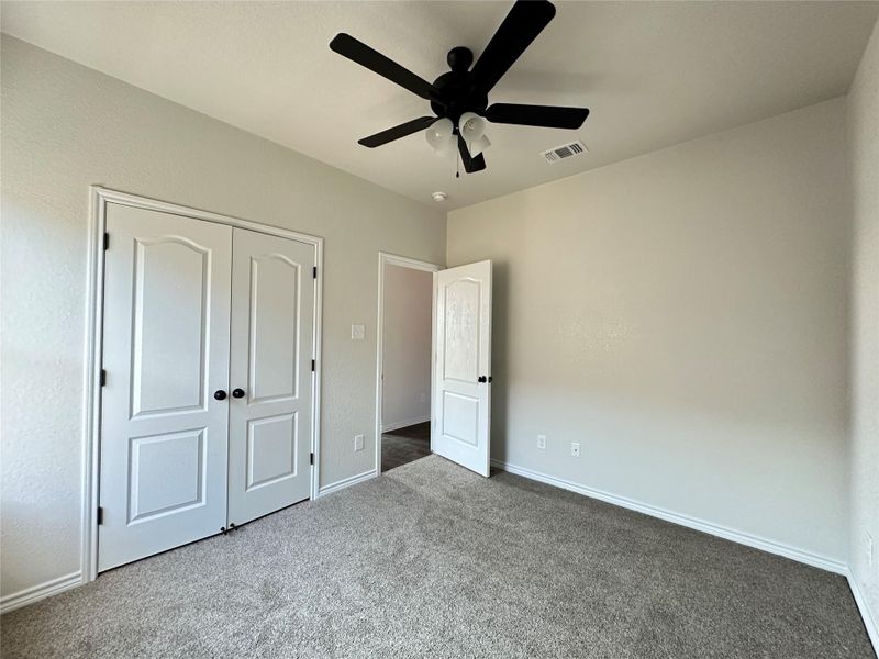 Unfurnished bedroom with carpet flooring, a closet, and a ceiling fan