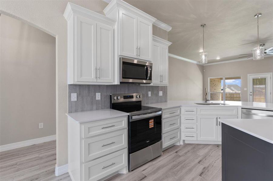 Modern kitchen featuring white shaker cabinetry, stainless steel appliances Modern kitchen featuring white shaker cabinetry, stainless steel appliances