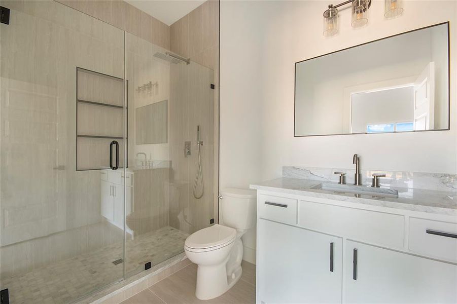 Full bathroom featuring vanity, a stall shower, and light tile patterned floors Full bathroom featuring vanity, a stall shower, and light tile patterned floors