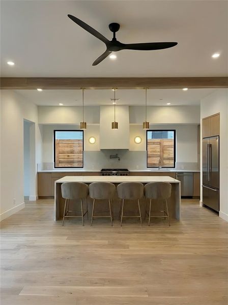 Kitchen- Chef's kitchen with custom cabinetry, waterfall island, Jenair appliance package, and brushed brass pendant lighting. (Rendering)