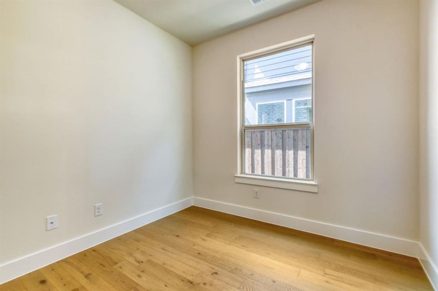Empty room with baseboards and light wood finished floors Empty room with baseboards and light wood finished floors