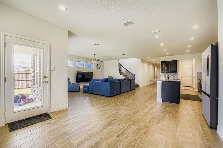 Kitchen featuring open floor plan, an island with sink, a kitchen breakfast bar, smart refrigerator, and recessed lighting Kitchen featuring open floor plan, an island with sink, a kitchen breakfast bar, smart refrigerator, and recessed lighting