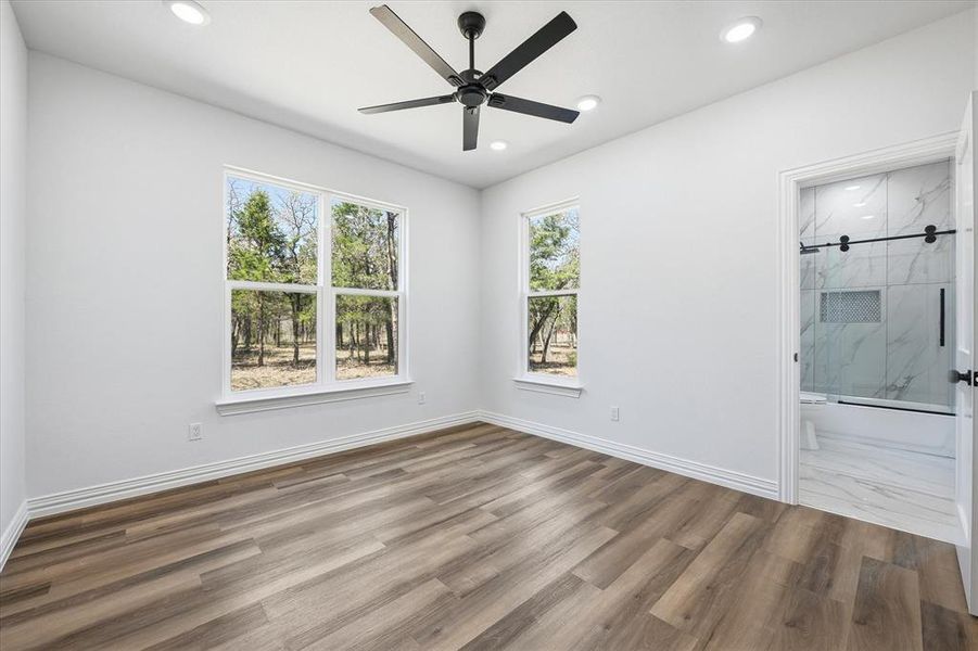 Unfurnished room featuring a ceiling fan, dark wood-type flooring, plenty of natural light, and recessed lighting