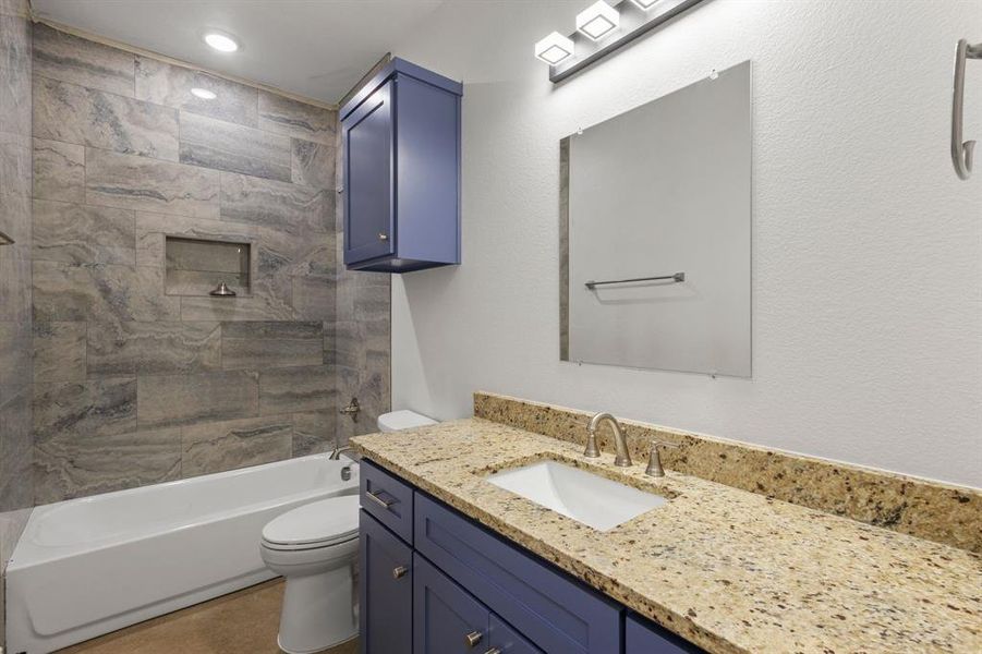 Full bathroom featuring vanity, toilet, and tiled shower / bath combo