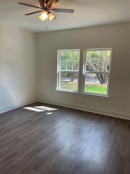 Unfurnished room with ceiling fan and dark wood-type flooring