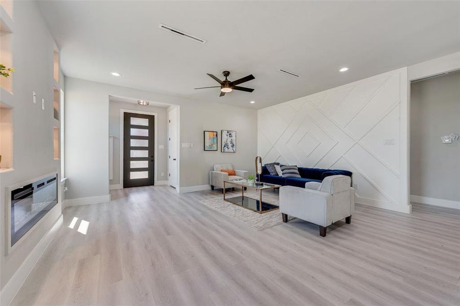 Living room featuring heating unit, light hardwood / wood-style floors, and ceiling fan