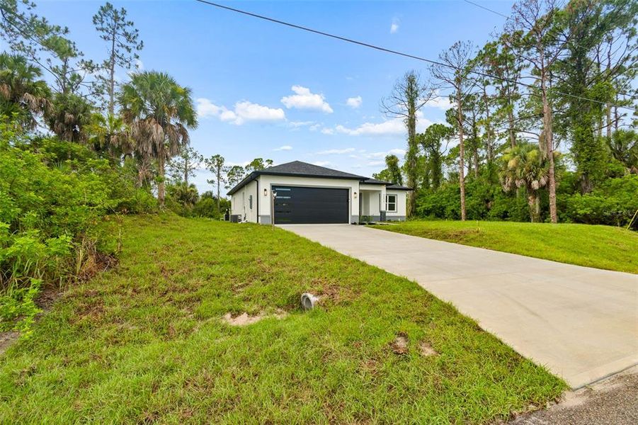 Front exterior of a new home in , North Port, FL, highlighting curb appeal (Image 31). Front exterior of a new home in , North Port, FL, highlighting curb appeal (Image 31).