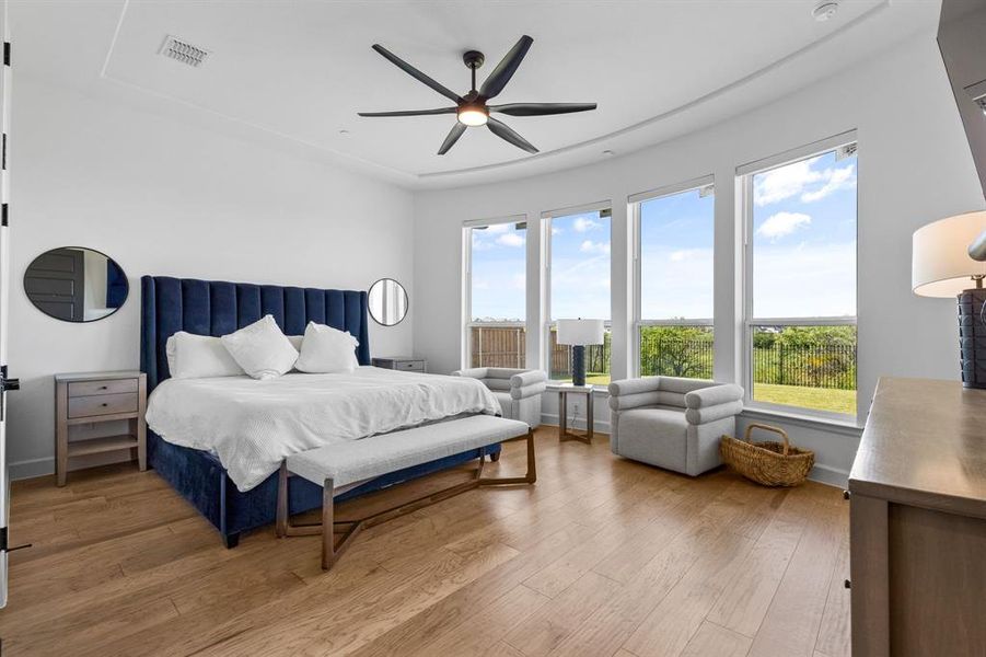 Bedroom featuring light wood-type flooring and ceiling fan Bedroom featuring light wood-type flooring and ceiling fan