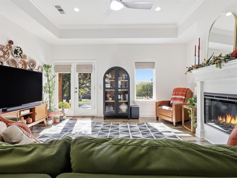 Living room with wood finished floors, ornamental molding, ceiling fan, french doors, and recessed lighting