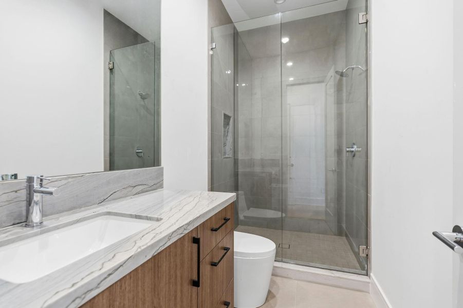 Guest bathrooms with Grohe fixtures and White Maldives natural stone countertops.