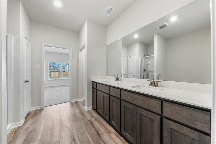 Bathroom with hardwood / wood-style floors, vanity, and walk in shower