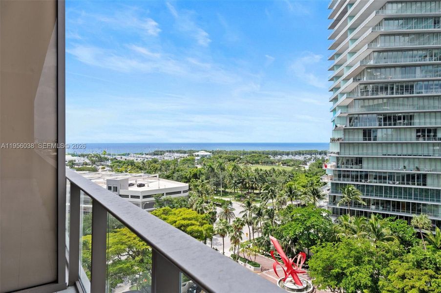 Spacious private balcony with serene views of Coconut Grove, lush greenery, marina, and skyline—perfect for morning coffee or sunset relaxation at Mr. C Residences.