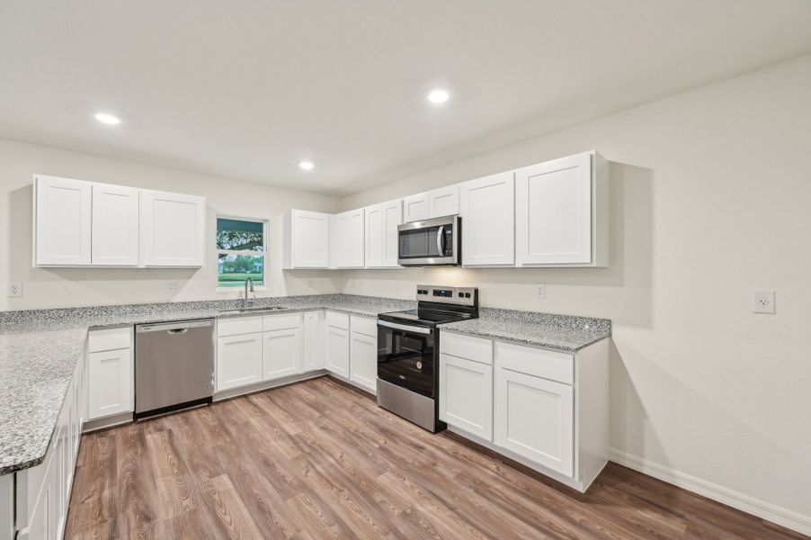 A kitchen with white cabinets.