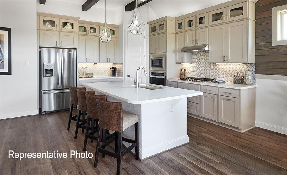 Contemporary kitchen featuring a spacious center island with seating, stainless steel appliances, and wood-finish flooring