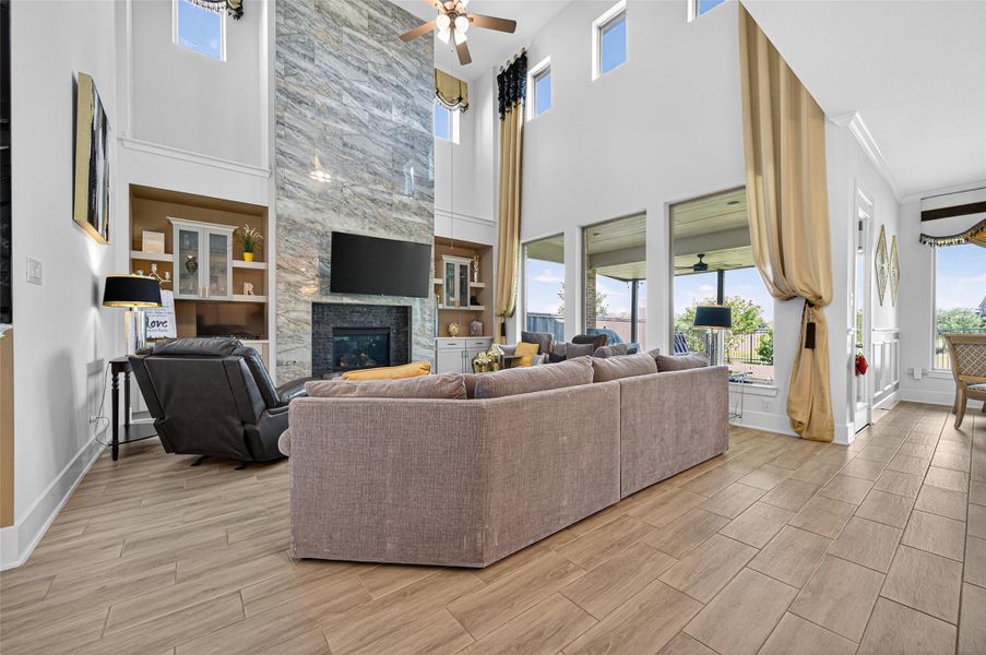 This spacious living room features high ceilings and abundant natural light from large windows. A modern stone fireplace serves as a focal point, complemented by a cozy sectional sofa and stylish decor. The open layout flows seamlessly to an outdoor patio, ideal for entertaining. This spacious living room features high ceilings and abundant natural light from large windows. A modern stone fireplace serves as a focal point, complemented by a cozy sectional sofa and stylish decor. The open layout flows seamlessly to an outdoor patio, ideal for entertaining.