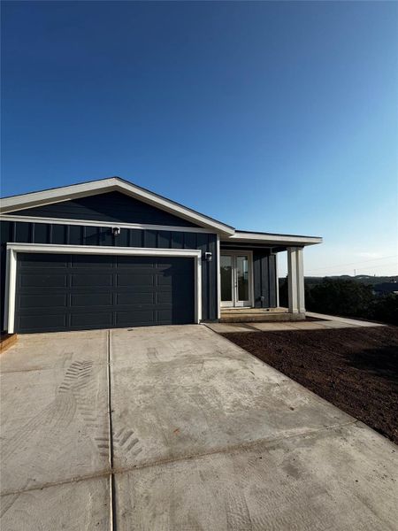 View of front of property with driveway, a garage, and board and batten siding View of front of property with driveway, a garage, and board and batten siding