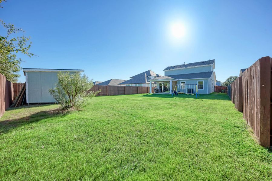 Fenced backyard with a patio