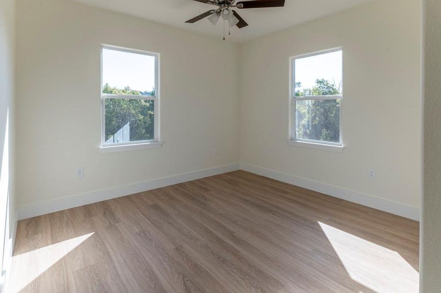 Empty room with light wood-style floors and ceiling fan