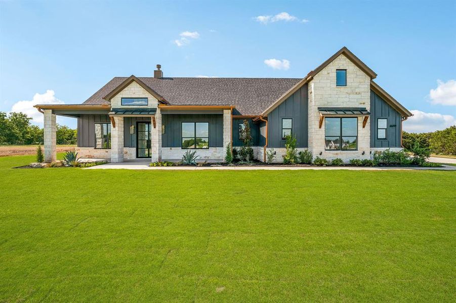 Modern farmhouse style home featuring a front yard