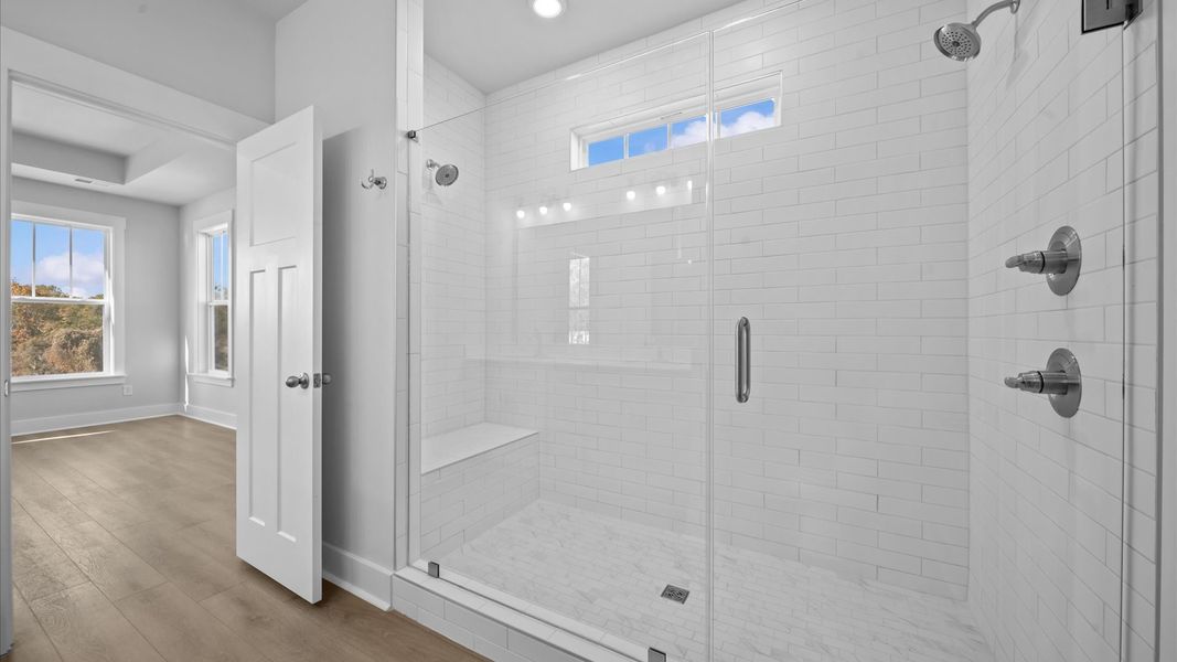 Exceptional en-suite with dual vanity and glass-enclosed tiled walk-in shower for superior everyday comfort