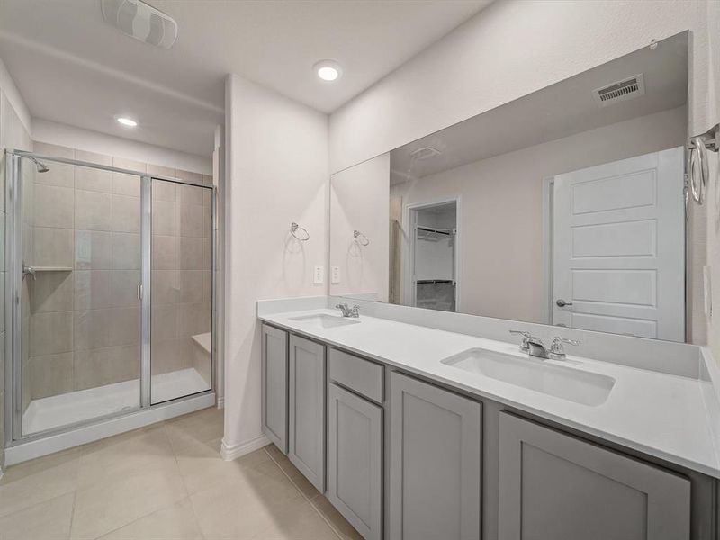 Full bathroom featuring a sink, tile patterned flooring, visible vents, and a shower stall