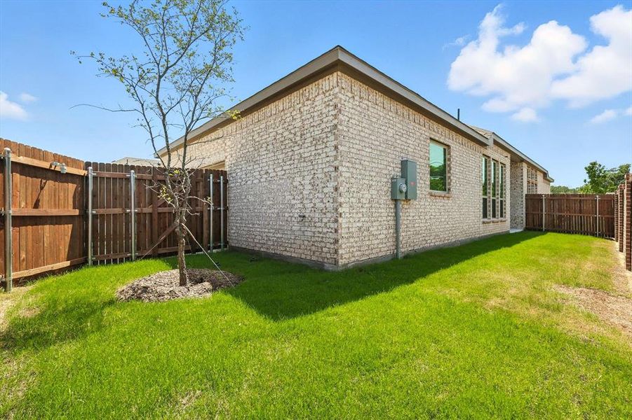 View of property exterior featuring brick siding and a fenced backyard View of property exterior featuring brick siding and a fenced backyard