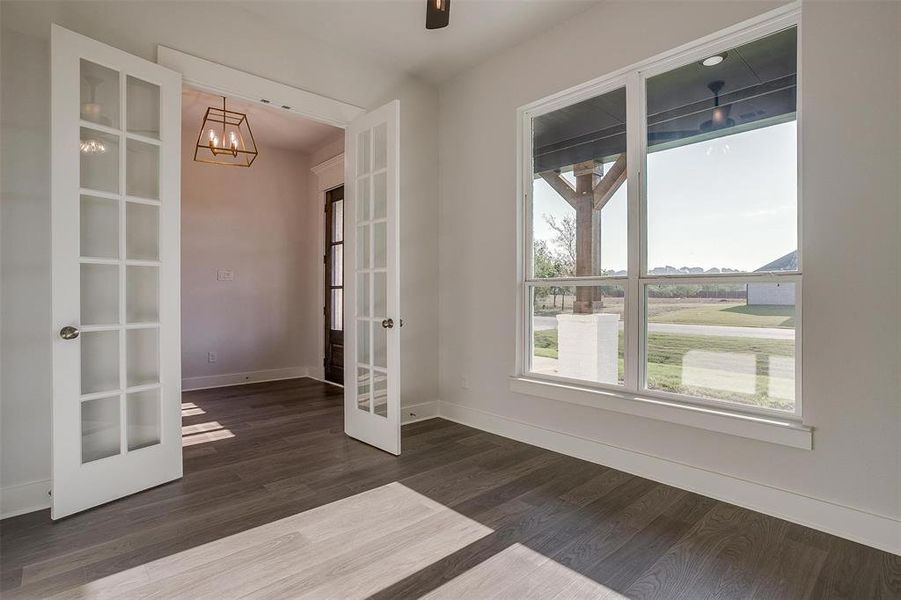 Empty room with dark hardwood / wood-style flooring and french doors