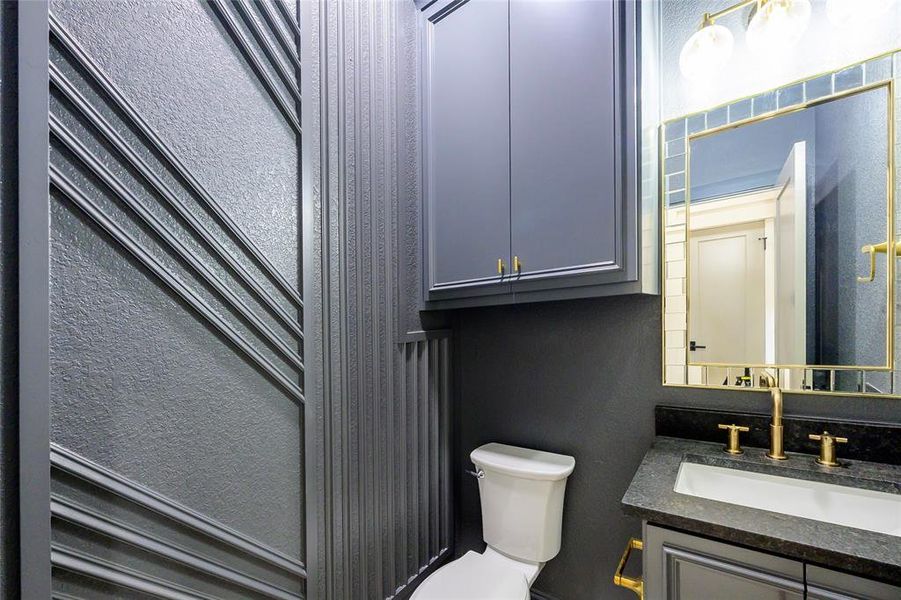 Half bath with a textured wall and vanity