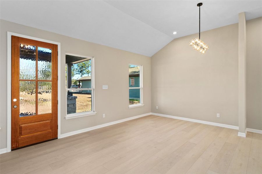Bright and welcoming entryview featuring a rich woodfront door with glass panels.Natural light streams throughside windows, highlightingthe airy, modern living room.