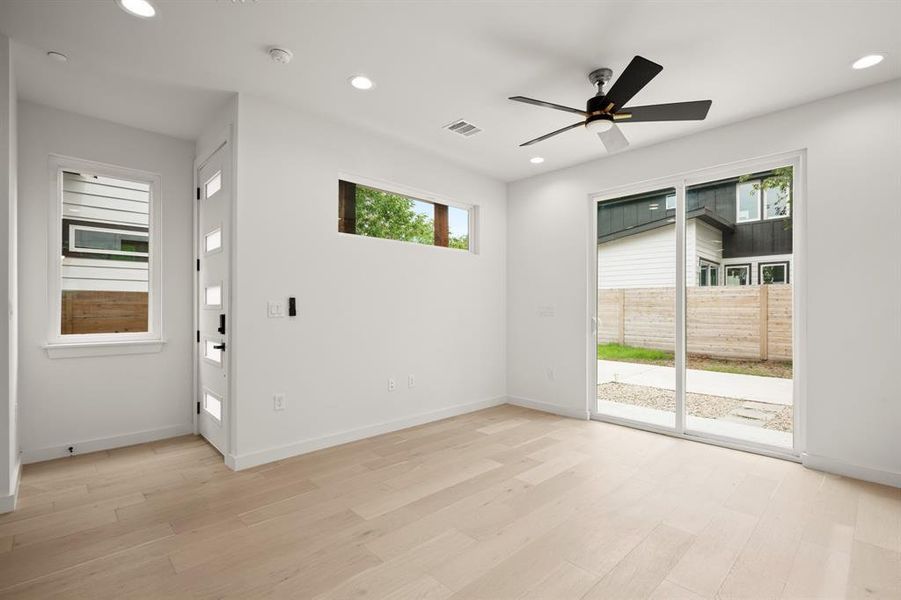 Entry into the Living room featuring healthy amount of natural light, ceiling fan, light wood finished floors, and recessed lighting