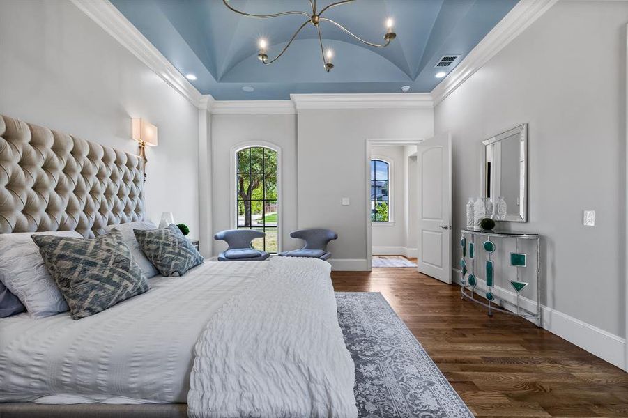 Bedroom featuring a chandelier, crown molding, a raised ceiling, high vaulted ceiling, and wood-type flooring