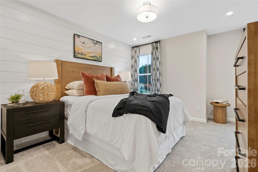 Secondary bedroom designed with accent shiplap wall.