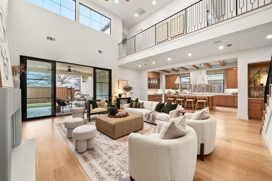 Living room with recessed lighting, light wood-style flooring, and a ceiling fan Living room with recessed lighting, light wood-style flooring, and a ceiling fan