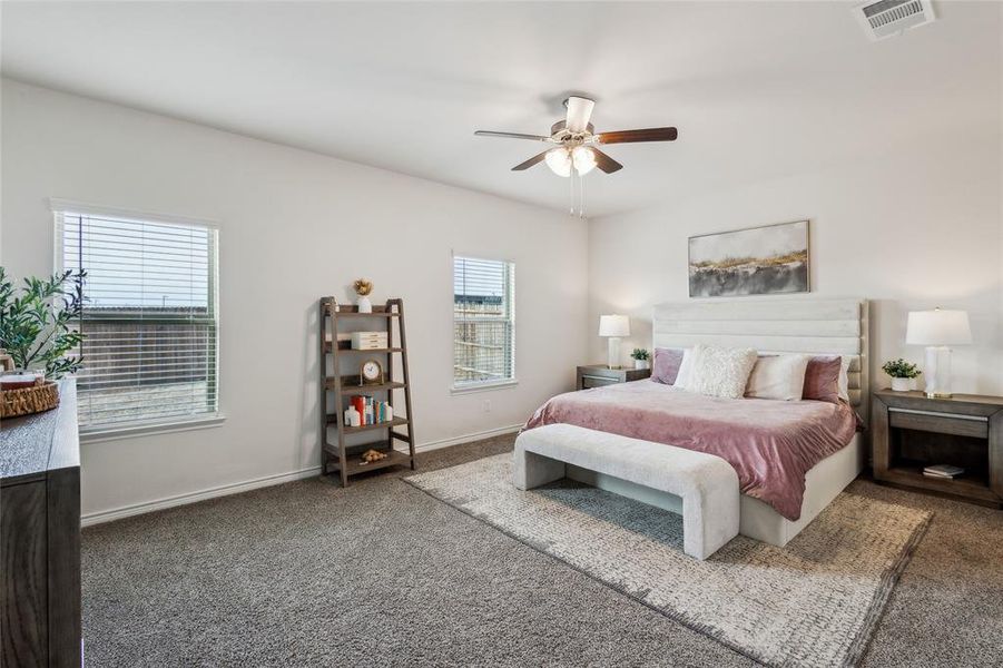 Bedroom with carpet floors, visible vents, baseboards, and a ceiling fan