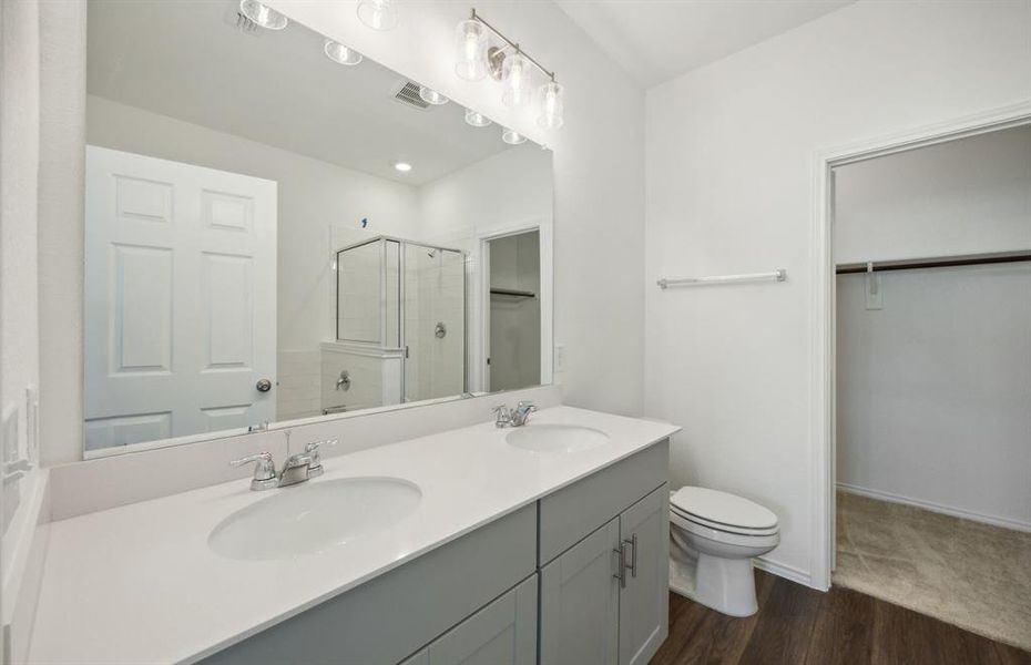 Elegant owner's suite with dual vanity *real home pictured