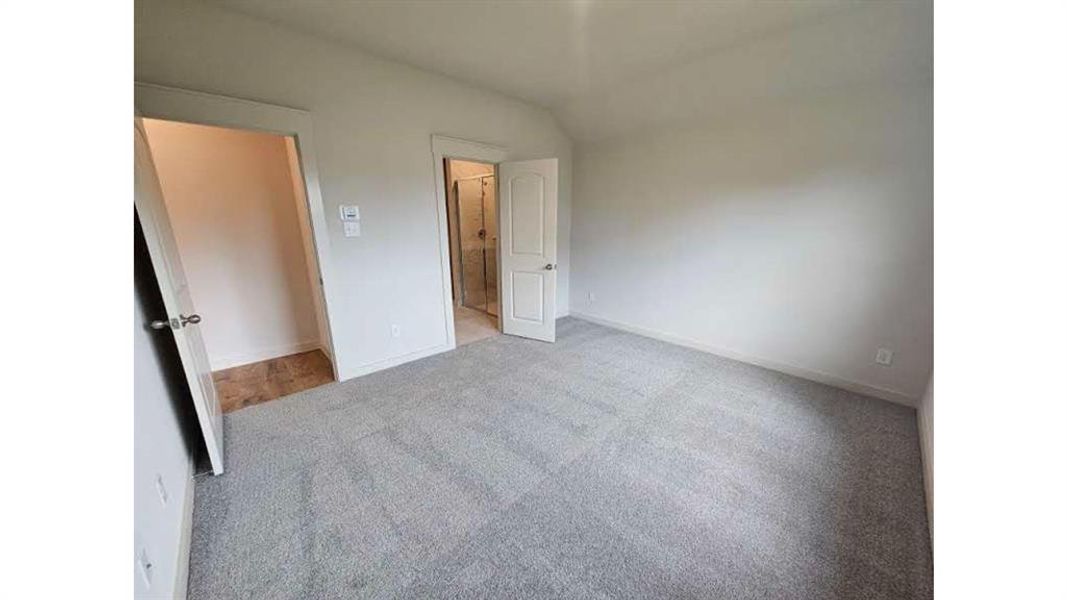 Spacious room featuring neutral carpeting and light-toned walls