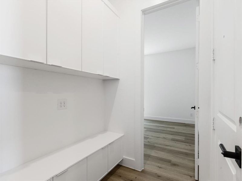 Mudroom featuring dark wood-style floors and baseboards