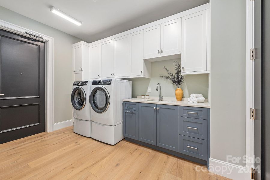 The laundry is ready to go, with a sink, washer and dryer included. Also a large pantry to the right side.