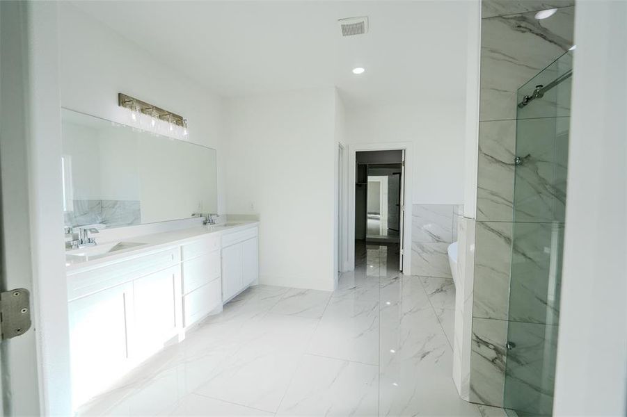 Bathroom with recessed lighting, double vanity, and light marble finish flooring Bathroom with recessed lighting, double vanity, and light marble finish flooring