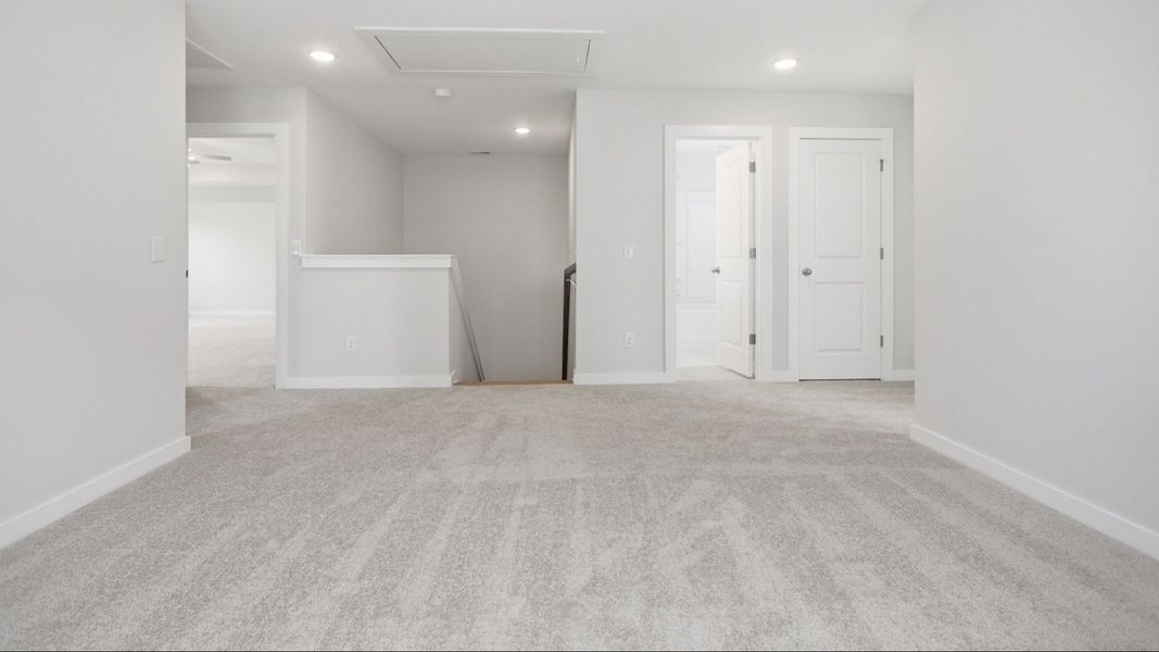 Second Floor Loft area with view of stairs with access to secondary bathroom, closet, and primary suite Second Floor Loft area with view of stairs with access to secondary bathroom, closet, and primary suite