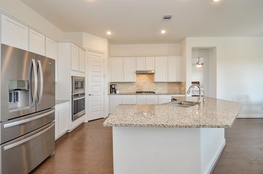 Bright kitchen with granite counters, large island, stainless steel appliances appliances