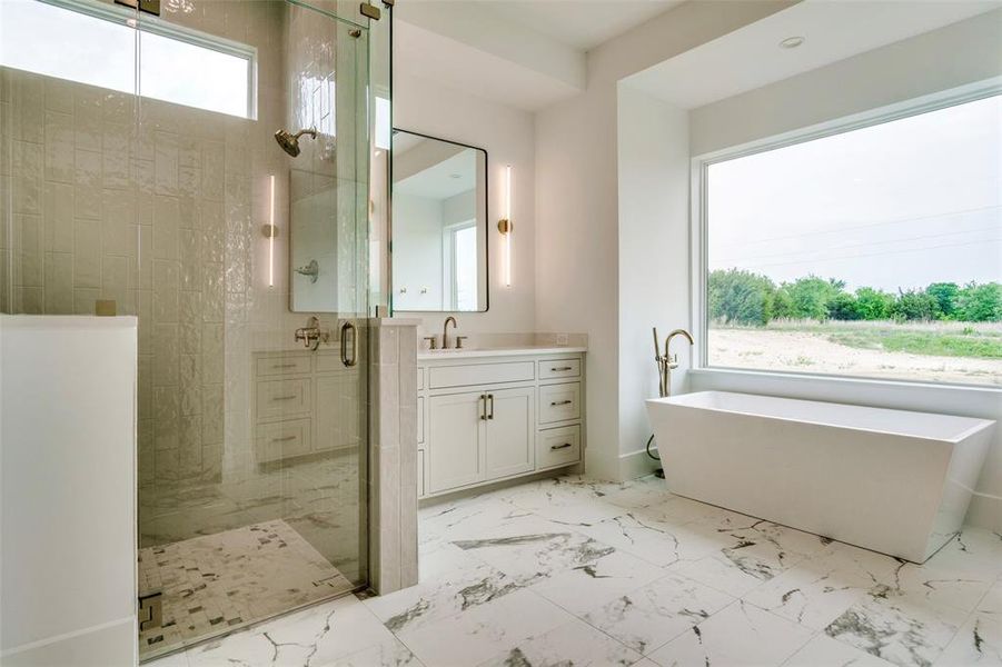 Bathroom featuring a soaking tub, vanity, marble finish floor, and a stall shower