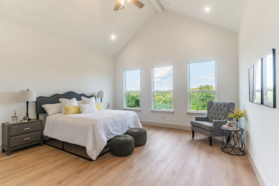 Bedroom featuring beam ceiling, light wood-type flooring, high vaulted ceiling, and ceiling fan Bedroom featuring beam ceiling, light wood-type flooring, high vaulted ceiling, and ceiling fan