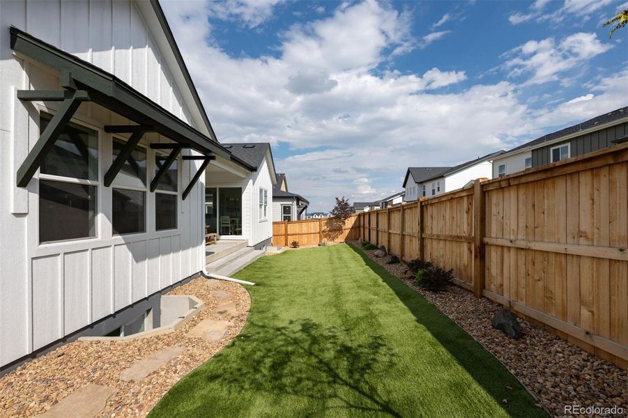 Upgraded landscaping in back yard with high quality pet friendly turf