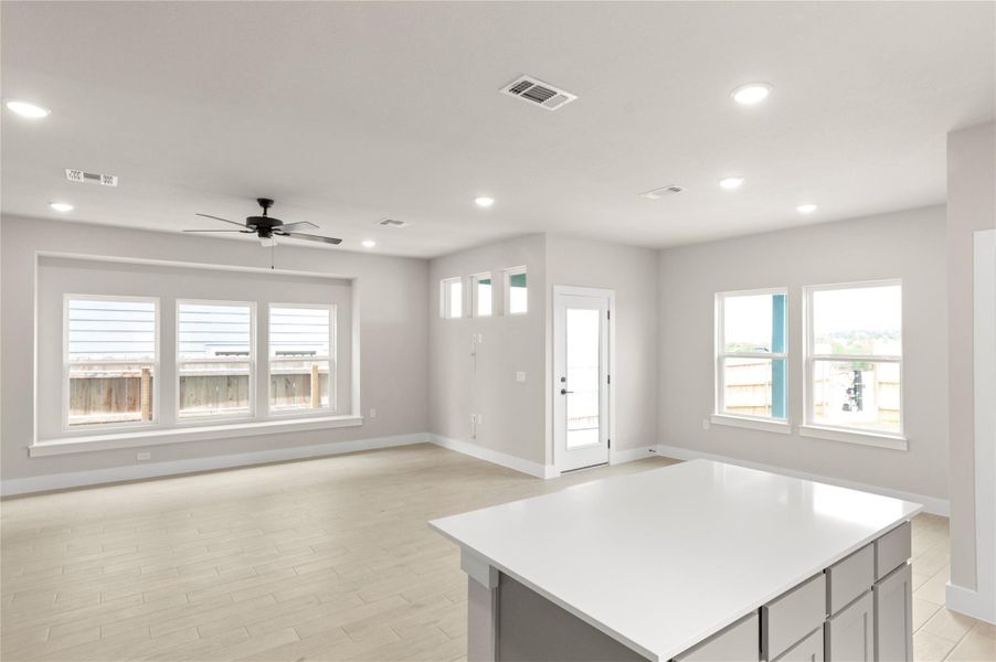 Kitchen featuring baseboards, recessed lighting, light countertops, open floor plan, and a ceiling fan Kitchen featuring baseboards, recessed lighting, light countertops, open floor plan, and a ceiling fan