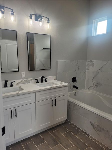 Full bath with double vanity and a garden tub