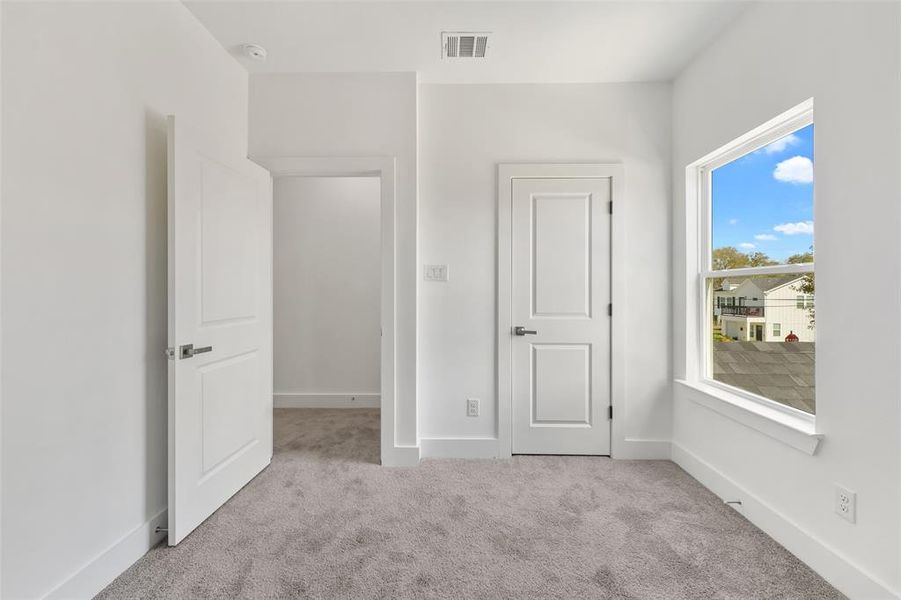 Unfurnished bedroom featuring light carpet