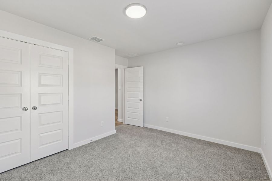 Bedroom in the Harrison home plan by Trophy Signature Homes – REPRESENTATIVE PHOTO